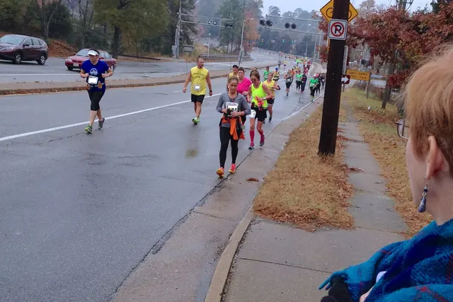 Maratonjuoksijoita sumuisella kadulla syksyisessä säässä